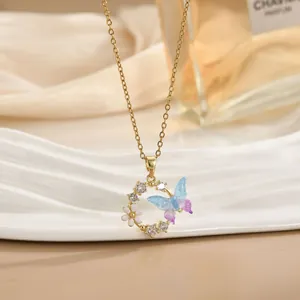 Elegante collana a farfalla dorata con ciondolo floreale in zircone su vassoio bianco