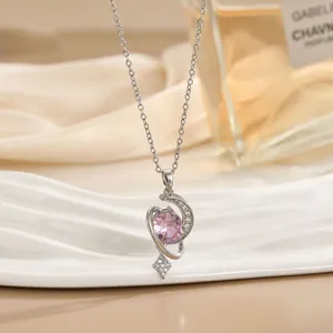 Detail van zilveren ketting met roze edelsteenhanger en sprankelende zirkonia