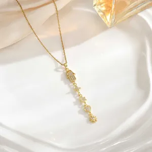 Detail view of gold long tassel necklace with sun, moon, and Hamsa hand charms on a tray