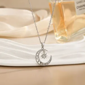 Detailopname van zilveren ketting met ster- en maanvanger en zirkonia op wit plateau