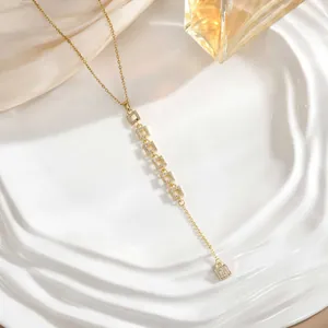 Detail of 18K gold Y-necklace with micro-pave zircon square modules on ceramic tray