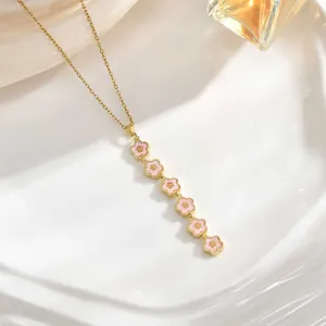 Long tassel necklace featuring six pink floral pendants on a gold chain detail