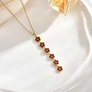 Detail of elegant gold chain with six vertically arranged dark red floral pendants