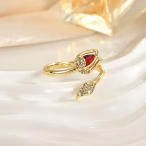 Close-up of golden tulip ring with a red teardrop stone and sparkling crystal accents