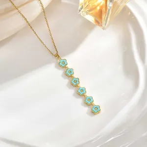 Detail of elegant gold necklace with six light blue enamel flowers on a silk backdrop
