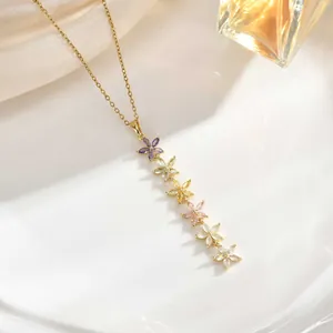 Detail of elegant gold necklace featuring six colorful zircon flower pendants on silk