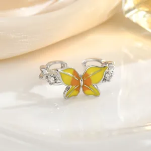 Detailed macro view of enamel butterfly ring with sparkling zircon and twisted silver band