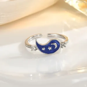 Detail of silver enamel ring featuring blue water-drop panel with crescent moon and stars