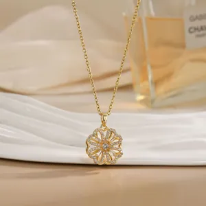Detailed view of a gold rotating flower pendant necklace with white cubic zirconia