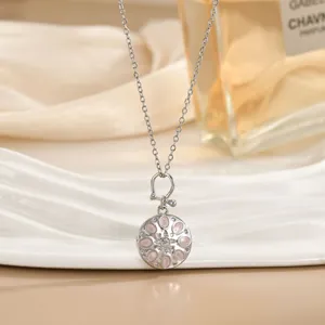 Detail van zilveren ketting met roze bloemenhanger en kleine heldere fonkelende strass