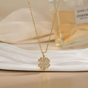 Detail of a rotating clover pendant in gold finish with sparkling pavé crystals