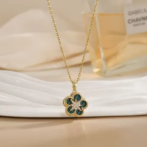 Macro detail of rotating flower pendant with green stripes and zircons on gold necklace