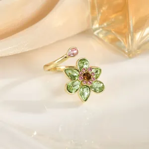 Detail of golden tulip ring featuring green petals and pink gemstone accents