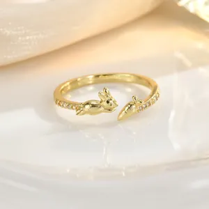 Macro shot of gold rabbit and carrot open ring with sparkling cubic zirconia inlay