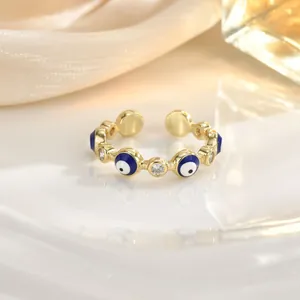 Macro detail of golden evil eye ring with blue enamel and sparkling zircon stones