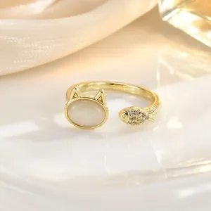 Detailed close-up of a gold-plated cat and fish open ring with cat's eye stone