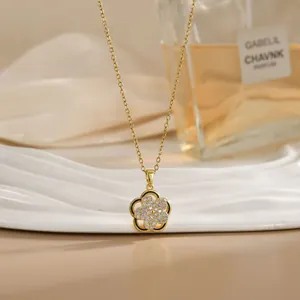 Detail of a rotating golden flower necklace with a sparkling center on a satin background