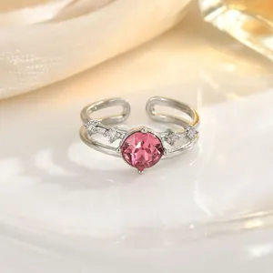 Detail of silver open ring with a large round pink crystal and tiny side stones