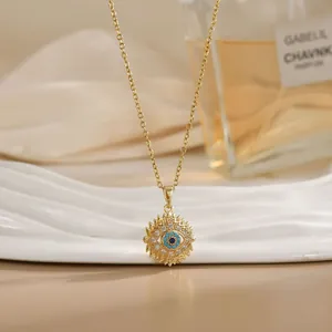 Close-up of golden sun-shaped pendant with turquoise evil eye and crystal inlays