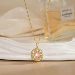 Detail of a rotating pink sunflower pendant on a gold titanium steel necklace with crystals