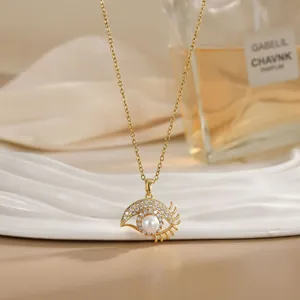 Close-up of golden spinning flower necklace with evil eye pendant and white pearl