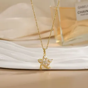 Detailed close-up of golden spinning flower pendant with zircons on white display