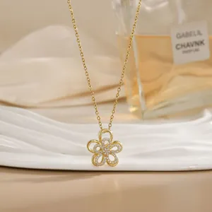 Close-up of a golden spinning flower pendant necklace with crystals on a white board