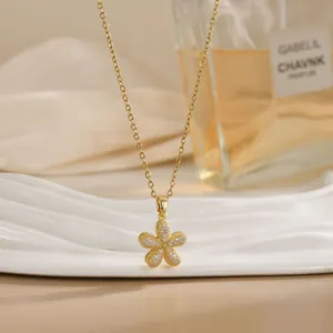 Detail of a rotating flower pendant necklace with white zircons on a wavy ceramic stand
