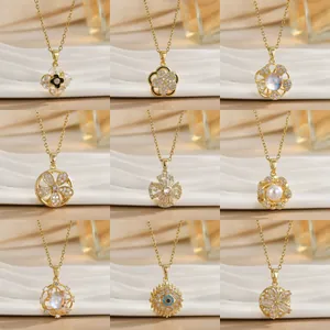 Collection of nine gold titanium necklaces with floral and lucky charms on silk background