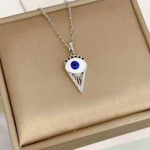 Modern Evil Eye necklace featuring a triangular silver pendant on a champagne gift box