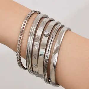Set di bracciali rigidi argentati con ciondoli a cuore e pietre di zirconi lucidi