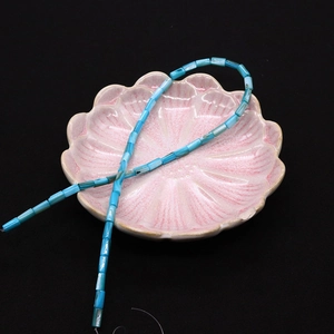 Dettaglio di perle cilindriche in conchiglia blu cielo su un vassoio rosa a petalo