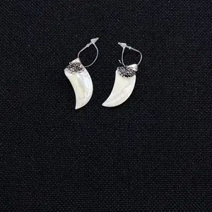 Detailopname van schelpvormige hangers met fonkelende donkere strass-steentjes op stof