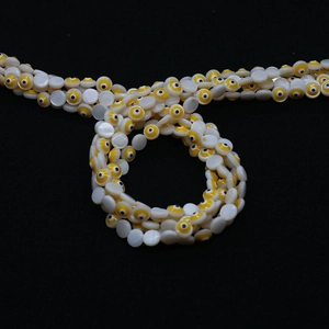 Makrodetail von runden Muschelperlen mit Evil-Eye-Muster für DIY-Schmuckherstellung