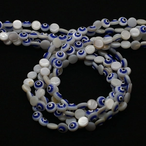 Makroaufnahme von Naturmuschelperlen mit Evil Eye Muster und buntem Emaille-Finish