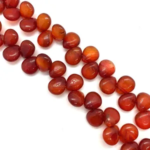 Detail of teardrop-shaped red agate stone beads with polished glass luster for jewelry DIY