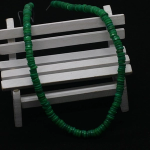 Close-up of green natural shell disc beads on a necklace with a metal clasp