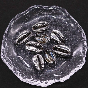 Detailansicht von acht gun-schwarzen Muschelperlen mit Gewindestruktur in einer Glasschale
