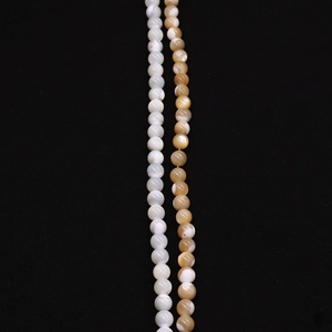Macro detail of natural seashell round beads with polished finish and unique banded texture