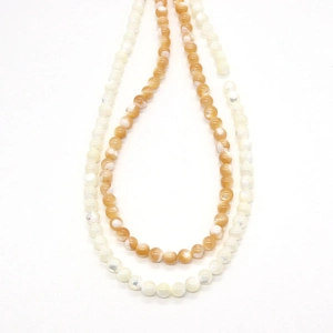 Polished natural shell round beads in cream and light orange with cat eye luster effect
