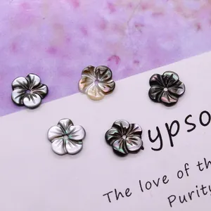 Macro detail of five-petal natural black shell flower beads with pearl luster and center hole