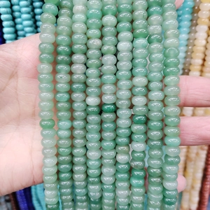 Detalle macro de cuentas de piedra aventurina verde claro natural de forma redonda plana para joyas