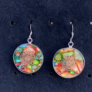 Detail of round earrings with multi-color stone inlay and gold floral hollow pattern