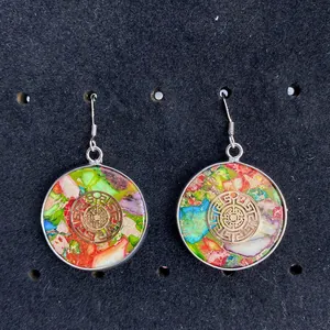 Close-up of bohemian round gemstone dangle earrings with golden pattern and multicolor stones