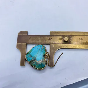Macro shot showing the 20mm width measurement of a heart-shaped turquoise earring pendant