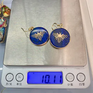 Detailed macro view of 10.11g lapis lazuli earrings with golden bee charms on scales