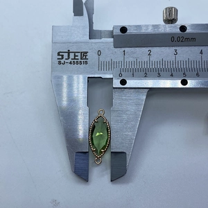 Messung des olivgrünen Marquise-Steinverbinders mit zwei Goldösen mit einem Messschieber