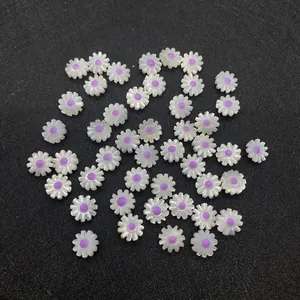 Dettaglio macro di perline a margherita bianche con centro viola per gioielli fai da te