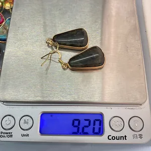 Detail shot showing a pair of natural stone earrings on a scale weighing 9.20 grams