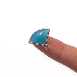 Natural sea blue faceted stone fan pendant with gold-plated edge on white background